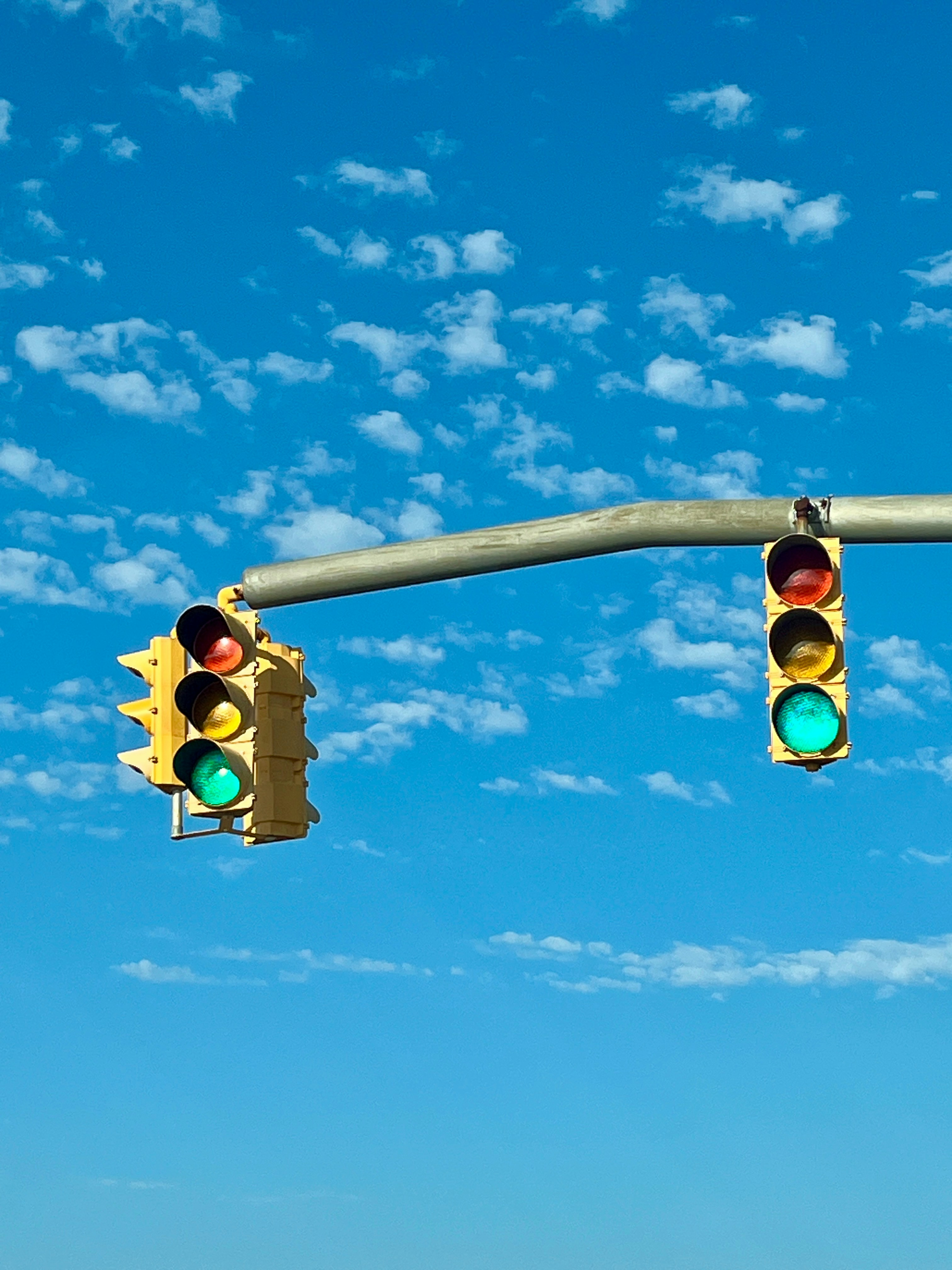 Traffic lights against a blue sky by Christy Hinko.